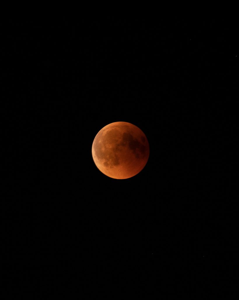 Captivating view of a blood moon during a lunar eclipse at night, showcasing the moon's surface features.