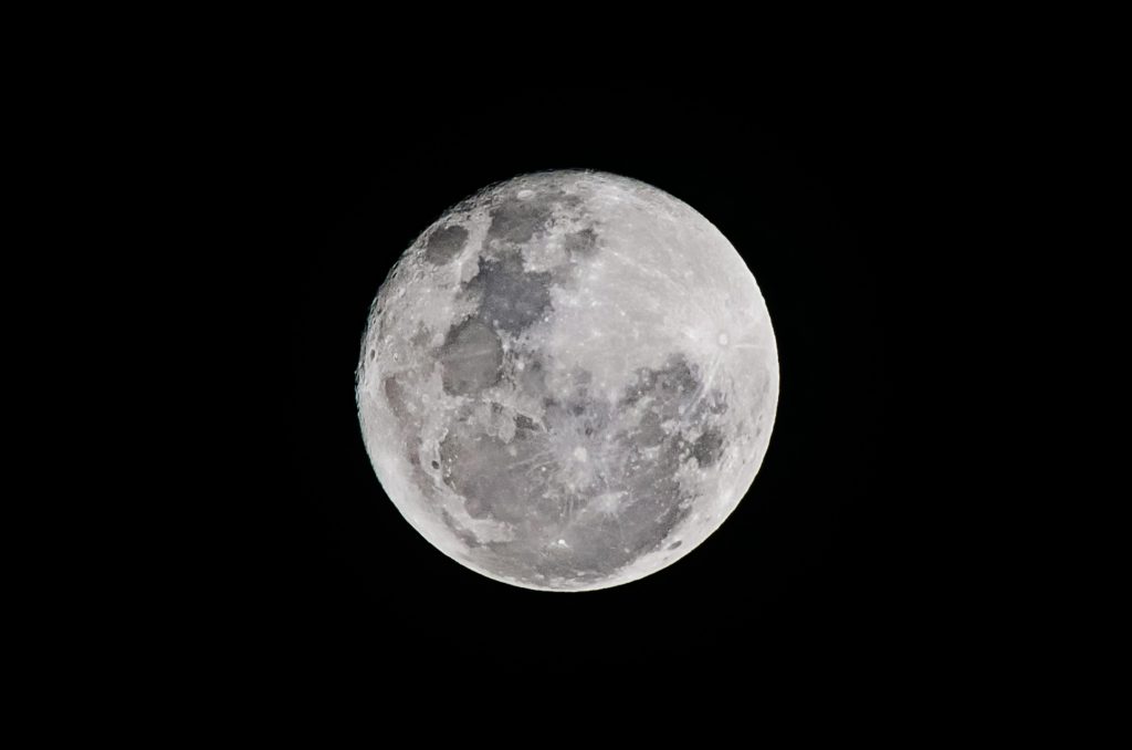 Detailed full moon captured against a black sky, showcasing lunar textures.