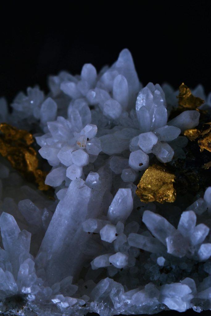 Detailed image of quartz crystals with gold elements, showcasing their natural beauty.