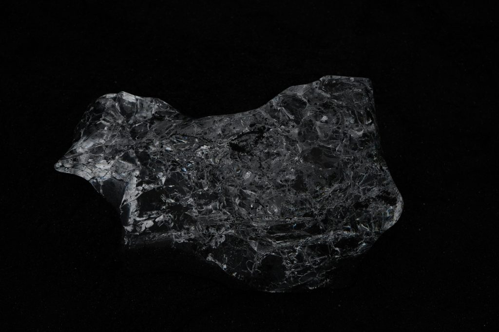 Dark glimmering mineral stone against a black background. Perfect for natural textures.